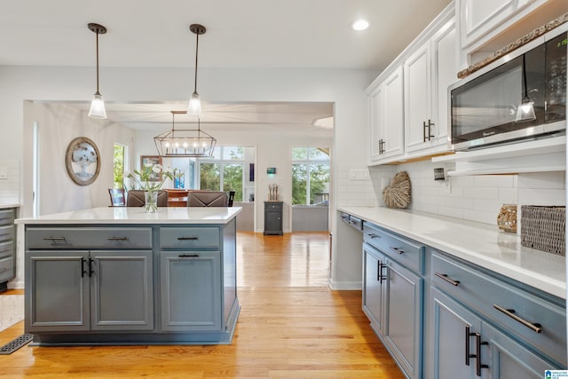 2616 Chimney Hills Cir, Vestavia Hills, AL 35226 - kitchen featuring stainless steel microwave, light wood-type flooring, white cabinets, tasteful backsplash, and light countertops