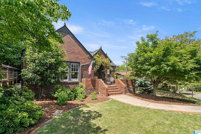 view of front of house featuring brick siding and a front lawn