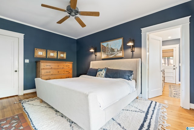 bedroom with wood finished floors, baseboards, ornamental molding, and a ceiling fan