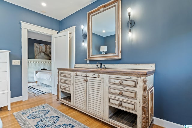 bathroom featuring wood finished floors, vanity, and baseboards