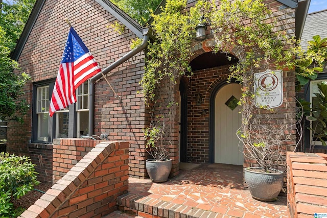 doorway to property featuring brick siding