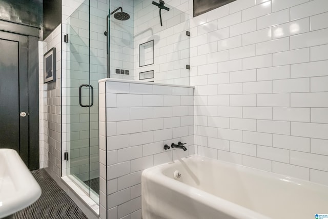 full bathroom featuring a stall shower, a bath, and a sink