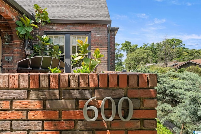 exterior view of a shingled roof, brick siding, and a downspout