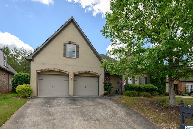 view of front facade with stucco siding, driveway, and an attached garage