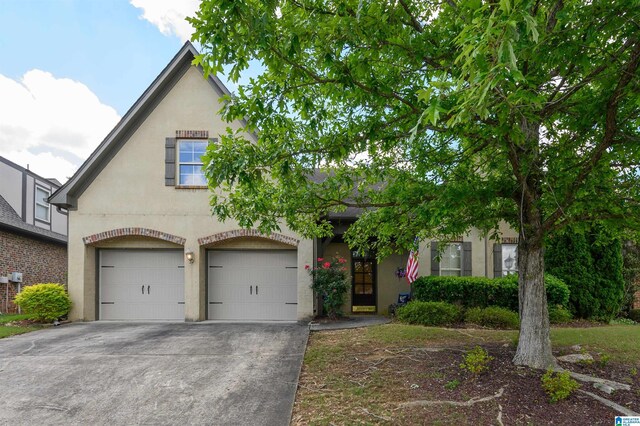 view of front of home featuring stucco siding, an attached garage, and driveway