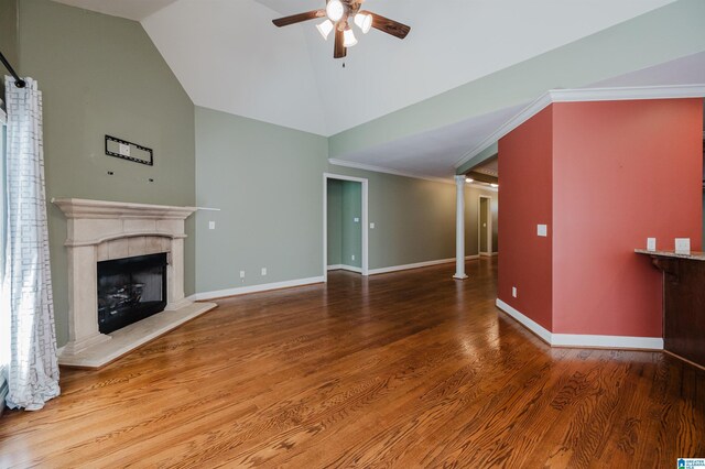 unfurnished living room with ceiling fan, a fireplace, high vaulted ceiling, wood finished floors, and baseboards