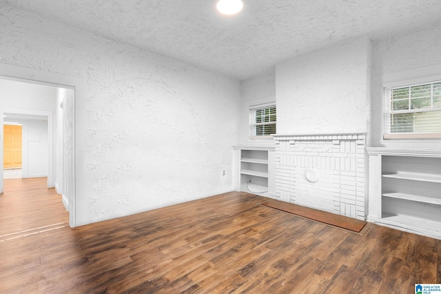 408 5th Pl, Birmingham, AL 35214 - unfurnished living room featuring a textured wall, wood finished floors, and a textured ceiling