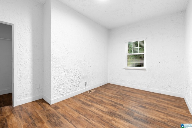 408 5th Pl, Birmingham, AL 35214 - empty room featuring wood finished floors, a textured wall, and baseboards