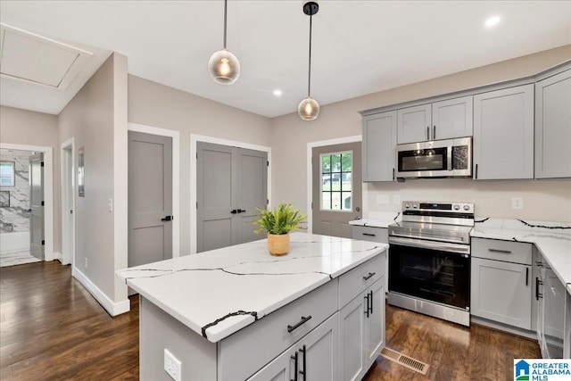 2624 29th St, Birmingham, AL 35208 - kitchen featuring stainless steel appliances, gray cabinets, dark wood finished floors, light stone countertops, and recessed lighting