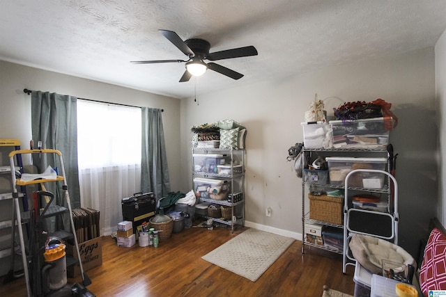 miscellaneous room featuring ceiling fan, wood finished floors, baseboards, and a textured ceiling
