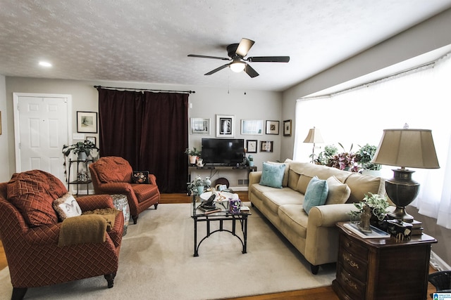 living area with a ceiling fan and carpet flooring