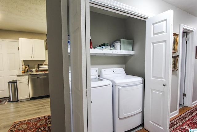 laundry area featuring light wood-type flooring and washer and clothes dryer