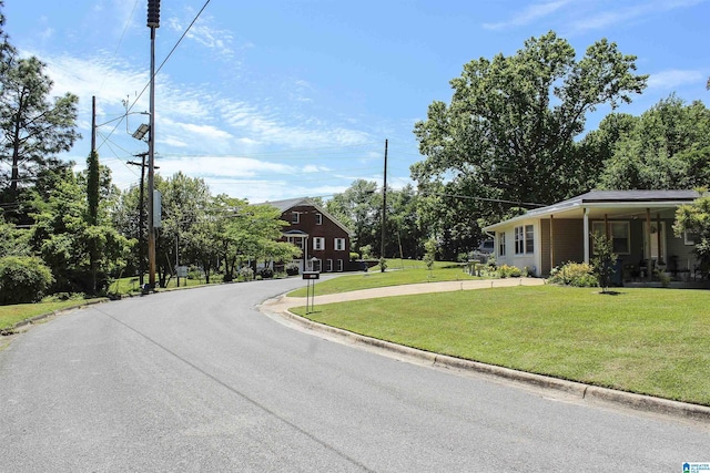 view of asphalt street with curbs