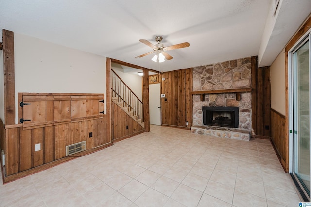 320 Cambo Ln, Hoover, AL 35244 - unfurnished living room with wooden walls, ceiling fan, stairs, a fireplace, and a wainscoted wall