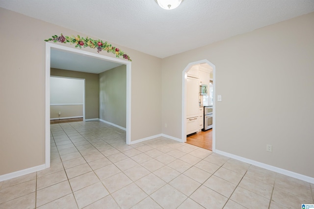 320 Cambo Ln, Hoover, AL 35244 - empty room with light tile patterned flooring, arched walkways, baseboards, and a textured ceiling