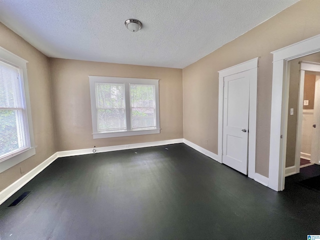 spare room featuring baseboards and a textured ceiling