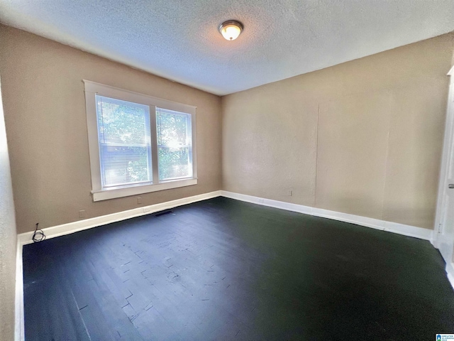 unfurnished room featuring baseboards, a textured ceiling, and dark wood-style floors