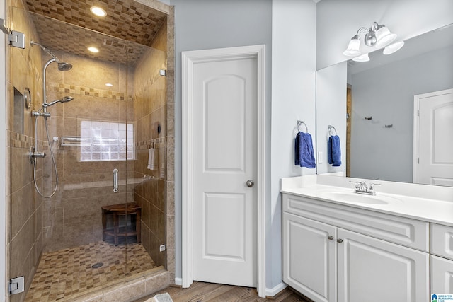 bathroom featuring a shower stall, vanity, and wood finished floors
