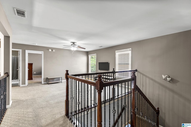 hall featuring an upstairs landing, carpet floors, and baseboards