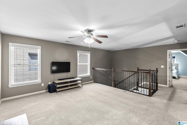 sitting room featuring an upstairs landing, carpet floors, ceiling fan, and baseboards