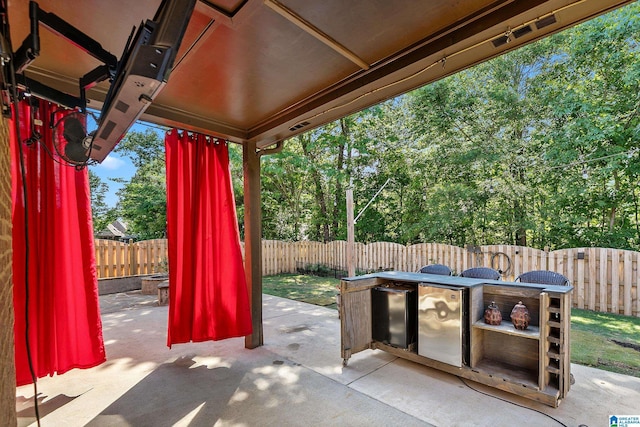 view of patio / terrace featuring a fenced backyard and view of wooded area