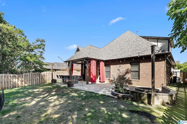 back of property with roof with shingles, a patio, and brick siding