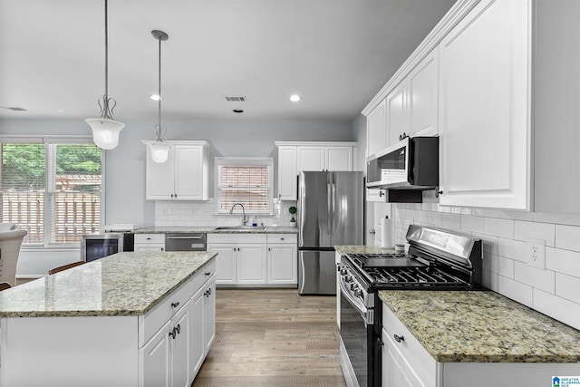 kitchen featuring appliances with stainless steel finishes, a sink, plenty of natural light, recessed lighting, and white cabinets