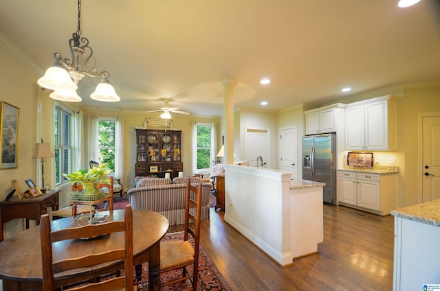 kitchen featuring stainless steel refrigerator with ice dispenser, dark wood-style floors, crown molding, white cabinetry, and a chandelier