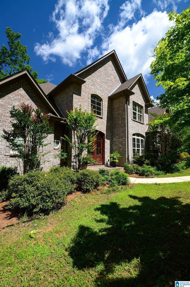 view of front of property featuring a front lawn and brick siding