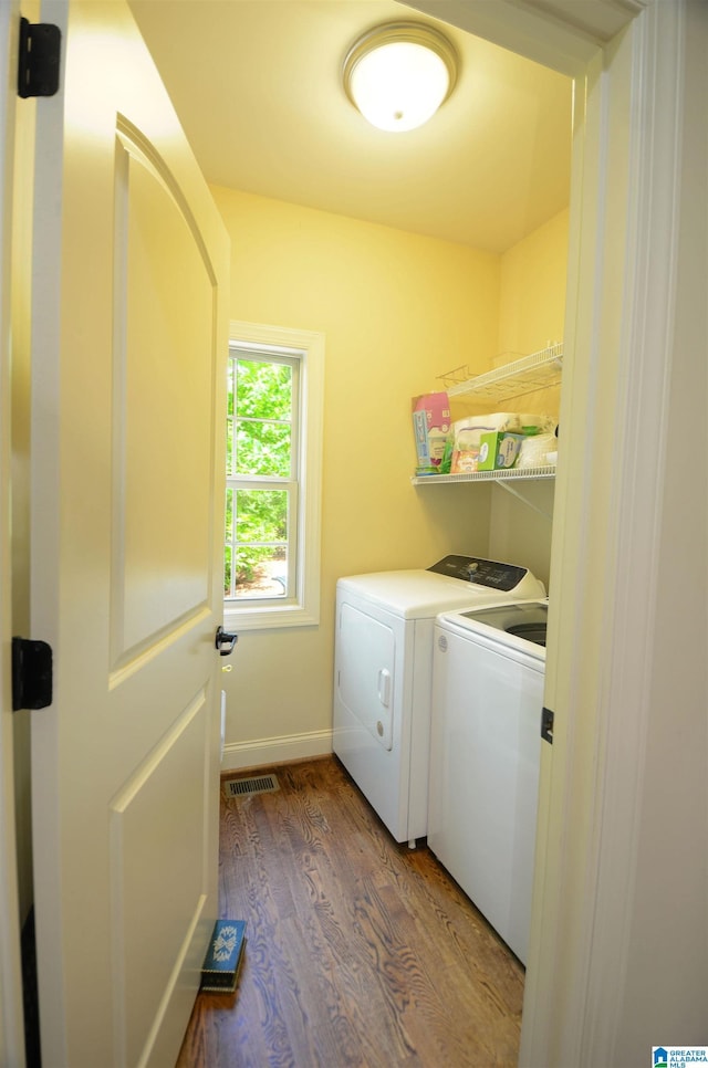 laundry area featuring independent washer and dryer, wood finished floors, and baseboards