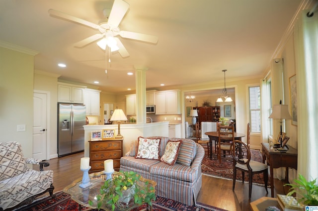 living room with wood finished floors, ceiling fan, ornamental molding, a chandelier, and recessed lighting
