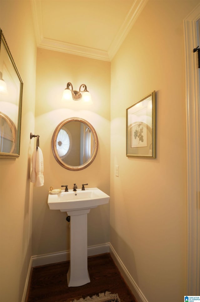 bathroom featuring wood finished floors, crown molding, and baseboards