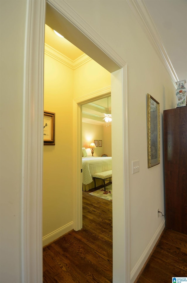hall featuring dark wood finished floors, ornamental molding, and baseboards