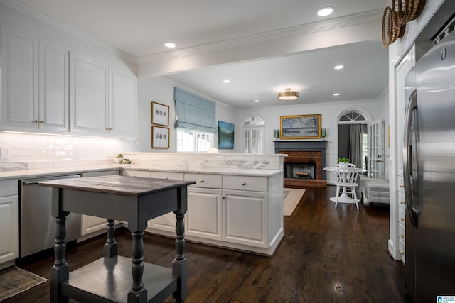 kitchen featuring appliances with stainless steel finishes, dark wood finished floors, white cabinets, a peninsula, and recessed lighting