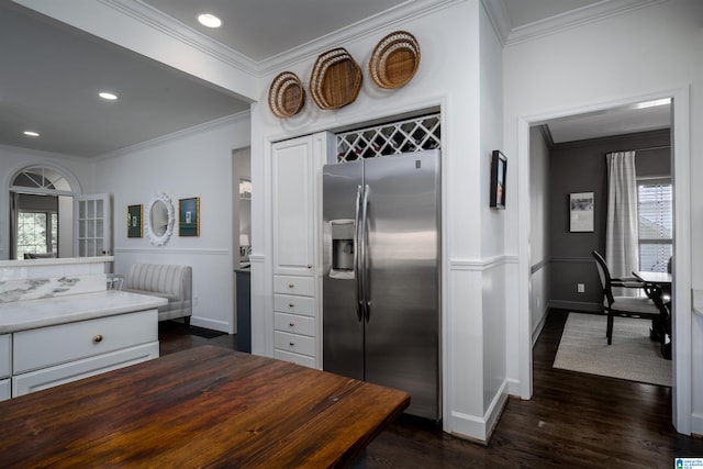 kitchen featuring stainless steel refrigerator with ice dispenser, plenty of natural light, ornamental molding, dark wood-style floors, and white cabinets