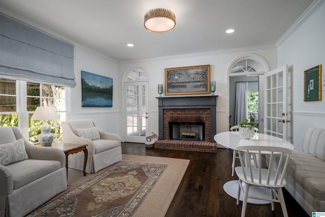 living room featuring ornamental molding, wood finished floors, a fireplace, wainscoting, and recessed lighting