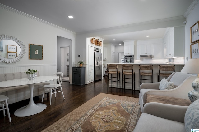 living room featuring dark wood-style floors, ornamental molding, a wainscoted wall, and recessed lighting