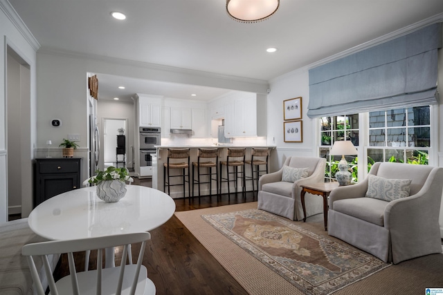 living area featuring ornamental molding, dark wood-style flooring, and recessed lighting