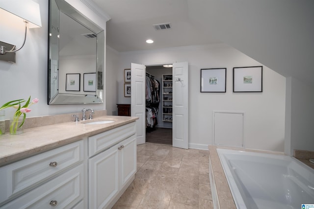 full bath with crown molding, vanity, a walk in closet, a bath, and recessed lighting