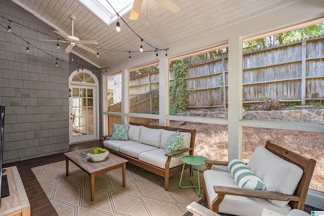 sunroom featuring ceiling fan, an outdoor hangout area, a skylight, and vaulted ceiling