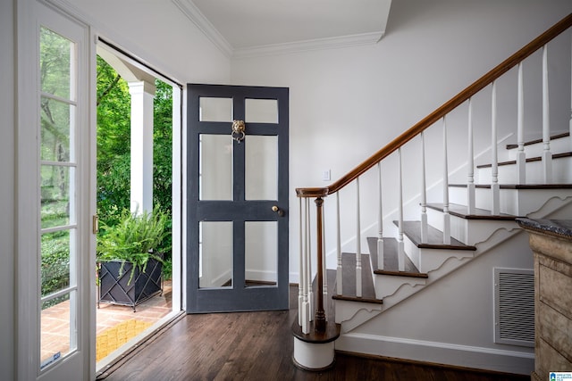 foyer entrance featuring ornamental molding, wood finished floors, stairway, and baseboards