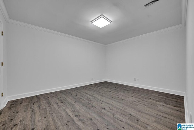 spare room featuring ornamental molding, wood finished floors, and baseboards