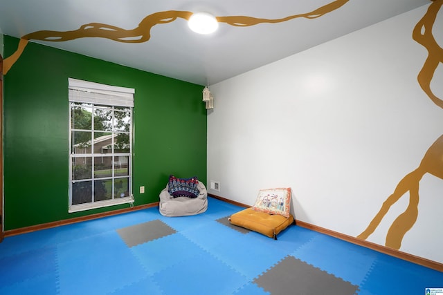 recreation room featuring carpet floors and baseboards