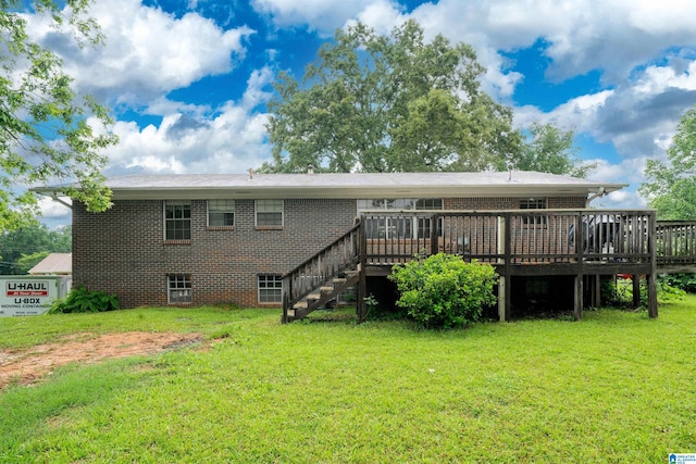 back of house featuring brick siding, a deck, a yard, and stairway
