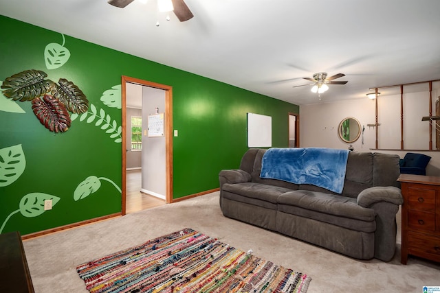 carpeted living area featuring a ceiling fan and baseboards