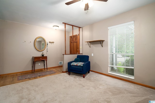 living area with ceiling fan, carpet, and baseboards