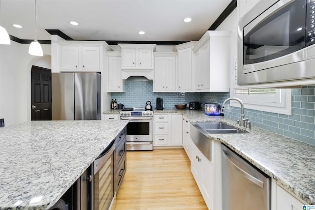4017 Milner Way, Birmingham, AL 35242 - kitchen with appliances with stainless steel finishes, white cabinets, light wood finished floors, beverage cooler, and a sink