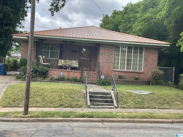 view of front of property featuring brick siding, covered porch, and metal roof