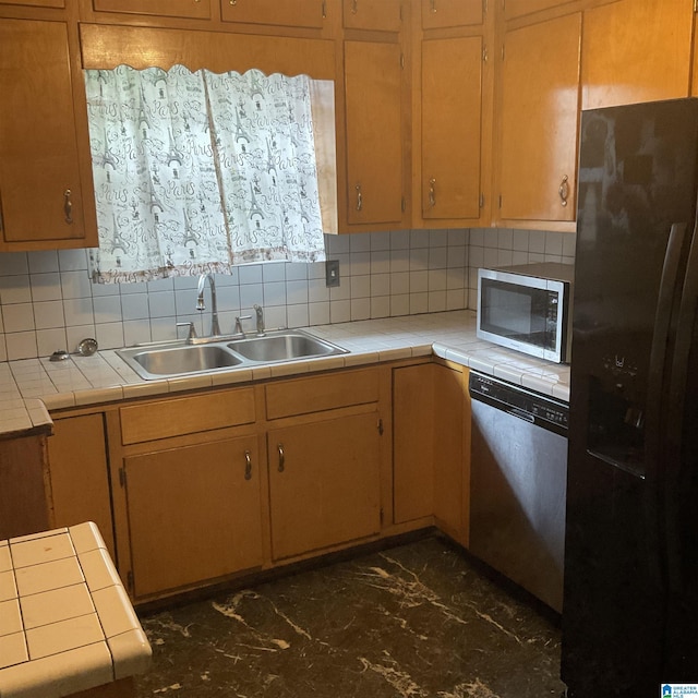 kitchen featuring appliances with stainless steel finishes, a sink, tile counters, and tasteful backsplash