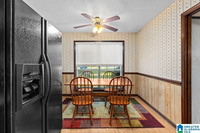5241 County Road 48, Jemison, AL 35085 - dining area featuring wallpapered walls, wainscoting, ceiling fan, a textured ceiling, and wood finished floors